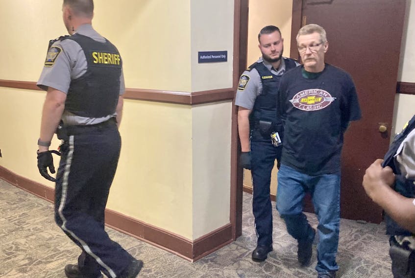 Ian Edward Craig Warner, 58, of Terence Bay is led into Halifax provincial court Monday. Warner was supposed to stand trial on two counts of break and enter and single counts of sexual assault and property mischief, but the hearing had to be adjourned after he fired his lawyer.