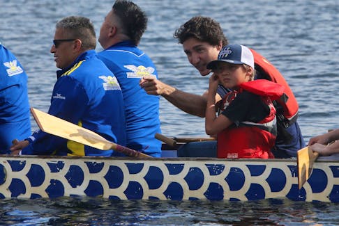 Canadian Prime Minister Justin Trudeau and his son, Hadrian, paddle with Indigenous dignitaries for the opening of the canoe kayak event for the North American Indigenous games on Lake Banook in Dartmouth Monday, July 17, 2023.