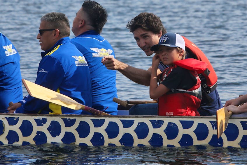 Canadian Prime Minister Justin Trudeau and his son, Hadrian, paddle with Indigenous dignitaries for the opening of the canoe kayak event for the North American Indigenous games on Lake Banook in Dartmouth Monday, July 17, 2023.