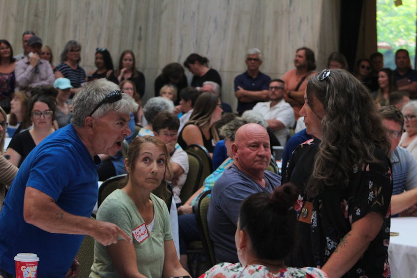 Members of the crowd get into a heated argument during the public information seminar held at the Confederation Centre of the Arts on July 19. Rafe Wright • The Guardian