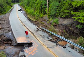 A bystander surveys a partially washed-out road near Woodville, Kings County, on Saturday. - Tim Krochak