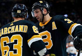 Brad Marchand and Patrice Bergeron have a discussion during a 2020 Boston Bruins game. - NHL
