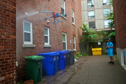 Adam Langilles a KTV working Drone pilot, washes the windows at a Morris Street apartment building in Halifax Wednesday July 19, 2023.

TIM KROCHAK PHOTO