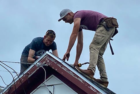 Mennonite Disaster Service volunteers Johan 'John' Friesen (left) and Cornelius Klassen are pictured working on a roof post-tropical storm Fiona.