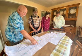 George Snell, left, EJ Gaudet, Jeanne Snell and Patricia Gaudet look at a Gaudet family tree. The poster traces siblings EJ and Jeanne's direct ancestors. – Kristin Gardiner/SaltWire