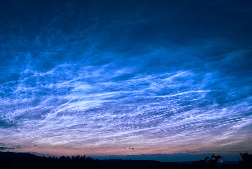 Light from the setting or rising sun illuminates noctilucent clouds from below, making them appear as whitish or pale blue wisps, streaks or swirls in the late-evening or predawn sky. Joshua Humpfer/Unsplash