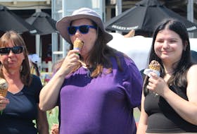 Charlottetown residents Janet Shera, left, Nikki Adam and Stephanie Adam attempt to beat the heat by enjoying some ice cream from Cows Creamery at Peake's Quay in Charlottetown on July 7. The three said they are considering attending the Cavendish Beach Music Festival, but the heat is a factor. Rafe Wright • The Guardian