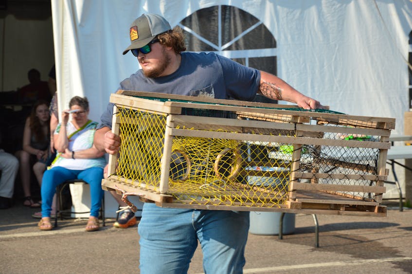 Ryan Murphy, the winner of the Journal Pioneer lobster trap stacking competition, carries a trap across the asphalt at the Lobster Carnival fairgrounds at Credit Union Place on Thursday, July 6. Murphy, a fisher out of Malpeque Bay, took home a $1,000 prize as the contest's winner. Kyle Reid