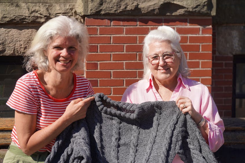 Carla DiGiorgio, left, Margot Maddison-MacFadyen, right, are holding the half-knitted jacket that was later completed by Carla. Vivian Ulinwa. The Guardian