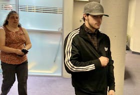 Brennan Conan Oake enters Dartmouth provincial court Tuesday with his mother. Oake, 23, pleaded guilty to a charge of distributing intimate images of a teenage girl without her consent and will be sentenced in November.