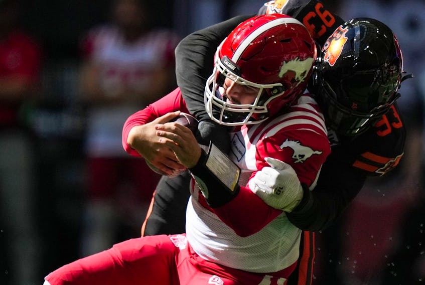  Calgary Stampeders quarterback Jake Maier, front, is sacked by B.C. Lions’ Amir Siddiqi during the first half of a CFL football game, in Vancouver, on Saturday, August 12, 2023.