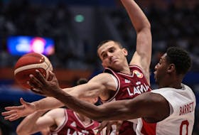 Canada's RJ Barrett (R) and Latvia's Andrejs Grazulis (C) vie for the ball during the FIBA Basketball World Cup group H match between Canada and Latvia at the Indonesia Arena in Jakarta on August 29, 2023.