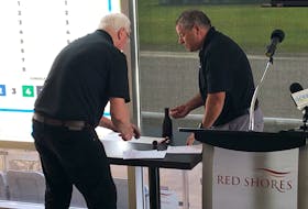 Gerard Smith, left, Red Shores race secretary, and Atlantic Provinces Harness Racing Commission official Kent Butler prepare the draw for three Gold Cup and Saucer Trials that will take place at Red Shores Racetrack and Casino at the Charlottetown Driving Park on Aug. 12 and 14. Jason Simmonds • The Guardian