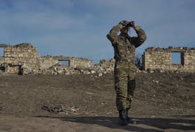 An ethnic Armenian soldier looks through binoculars as he stands at fighting positions near the village of Taghavard in the region of Nagorno-Karabakh in January 2021. -  REUTERS/Artem Mikryukov/File Photo