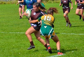 The Holland Hurricanes’ Bella Walsh, with ball, looks to avoid a tackle attempt by the St. Thomas Tommies’ Mackenzie Domres, 15, in an Atlantic Collegiate Athletic Association (ACAA) Women’s Rugby Conference game at the Co-op Field in Charlottetown on Sept. 10. The Hurricanes won the game 40-7. Jason Simmonds • The Guardian