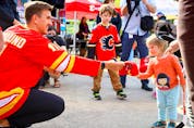  Mikael Backlund greets a young fan at a Calgary Flames Foundation event on May 11, 2023.
