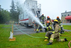 Cape Breton Regional Municipality Mayor Amanda McDougall uses a fire hose during Fire Ops 101 in Sydney on Monday. The event hosted by the International Association of Fire Fighters Local 2779 allows people to experience  what a day in the life of a firefighter is like. Photo by Al MacQueen