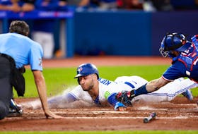 Blue Jays’ Kevin Kiermaier is tagged out at home plate by Rangers’ Jonah Heim at the Rogers Centre Monday night.  