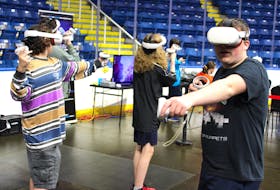 Convention-goers try out a virtual reality (VR) game at CaperCon 2023 at Centre 200 in Sydney on Saturday. Fans of movies, games and more ventured to the convention's second of three days, despite the uncertainty around what post-tropical storm Lee would bring to the region.
