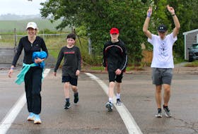 Steve MacNeil, right, raises his hands as he nears the end of the finish line during the Terry Fox Run in Sydney on Sunday. MacNeil has participated in every Terry Fox Run since the original Marathon of Hope took place in 1980. He is seen with Jennifer Weatherbee, from left, and her sons, Blake and Kyle Weatherbee. About 100 people took part in the Sydney run despite the rainy weather and organizers expected they would meet the $11,000 fundraising goal. Most of the nine other Terry Fox Run events in Cape Breton went ahead but a couple including the Glace Bay run were postponed until Sept. 24. CHRIS CONNORS/CAPE BRETON POST