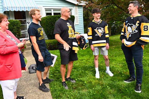 Sidney Crosby shares a laugh with some Pittsburgh Penguins fans after personally delivering their season tickets on Monday. - Pittsburgh Penguins