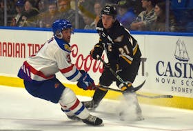 Zach Biggar of the Cape Breton Eagles, right, chips a puck past Olivier Boutin of the Moncton Wildcats during Quebec Major Junior Hockey League action at Centre 200 in Sydney on Friday. Moncton won the game 4-0. JEREMY FRASER/CAPE BRETON POST.