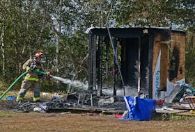 FOR NEWS STANDALONE:
A halifax firefighter douses small flare ups after crews knocked down a blaze that consumed a wooden homeless shelter, at the Green Road homeless encampment in Dartmouth Friday September 22, 2023. There were no injuries and a fire investigation is underway.

TIM KROCHAK PHOTO