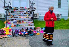 Georgina Doucette stands in front of Holy Family Catholic Parish church in Eskasoni. Each pair of shoes lining the entrance of the church symbolizes the missing and murdered Indigenous women and girls in Canada. - Contributed