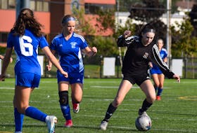 Taylor Hurley of the Breton Education Centre Bears, right, runs the ball up the field as she’s chased by Breagh Dolan of the Sydney Academy Wildcats, middle, during Cape Breton High School Soccer League action at Open Hearth Park in Sydney on Friday. BEC won the game 3-0. JEREMY FRASER/CAPE BRETON POST.