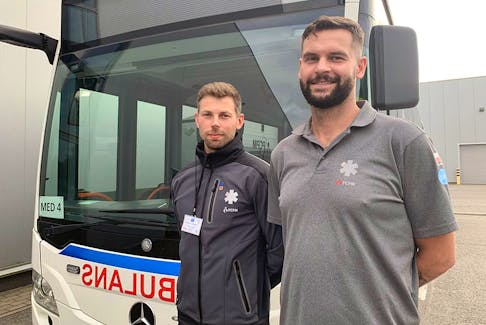  Mateusz Stojanowicz, right, and Wojciech Soliński, left, stand in front of the medevac hub facility’s bus ambulance at the Rzeszów-Jasionka Airport in Poland. The ambulance ferries patients to the airport from the medevac hub.