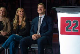 NHL superstar Nathan MacKinnon smiles as he watches a video tribute from Sidney Crosby along with his sister Sarah MacKinnon (left) and girlfriend Charlotte Walker during MacKinnon's Halifax Mooseheads jersey retirement ceremony on Friday, Sept. 22, 2023. 
Ryan Taplin - The Chronicle Herald