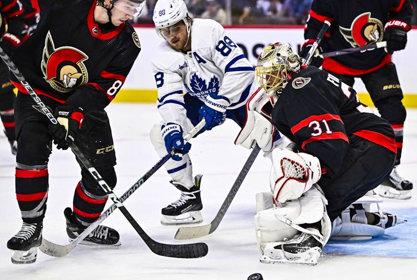 Maple Leafs' William Nylander  (88) looks for the puck as Ottawa Senators' Anton Forsberg and Jake Sanderson defend during third-period pre-season action in Ottawa, on Sunday, Sept. 24, 2023. 