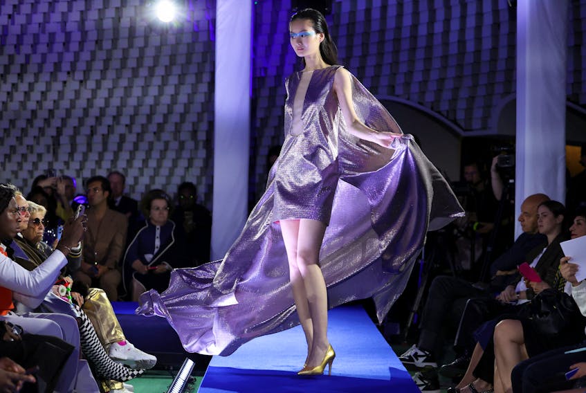 By Elizabeth Pineau and Geert De Clercq PARIS (Reuters) - Paris Fashion Week kicked off on Monday with a Pierre Cardin show in the headquarters of France's Communist Party, which was bathed in blue