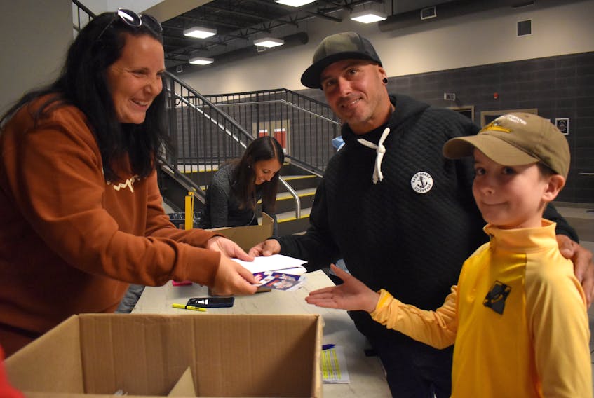 Grayson LeBlanc, right, and Stephen LeBlanc, middle, are shown picking up their tickets from Crystal Stockley at the Membertou Sport and Wellness Centre on Monday for the Kraft Hockeyville NHL pre-season game between the Florida Panthers and Ottawa Senators at Centre 200 in Sydney on Sunday. JEREMY FRASER/CAPE BRETON POST
