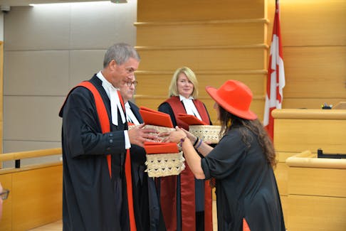 Julie Pellissier-Lush, right, of the Lennox Island First Nation presents P.E.I. provincial court's Chief Judge Jeff Lantz, left, with a sacred eagle feather on Sept. 27 as Chief Justice James Gormley, P.E.I. Court of Appeal, and P.E.I. Supreme Court Chief Justice Tracey Clements look on. The presentation was part of a ceremony at the Sir Louis Henry Davies Law Courts in Charlottetown to mark the inclusion of eagle feathers as another option (along with swearing on a Bible or affirming) for people to use in court matters for making an oath or an affirmation. Terrence McEachern • The Guardian