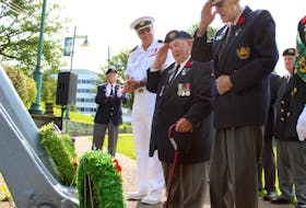 George Cann, left, and John Anstey salute after Cann laid a wreath during the Merchant Navy Veterans Day ceremony in Sydney on Sunday. At age 14, Cann was too young to enlist in the navy, army or air force so he joined the merchant navy during the Second World War. CHRIS CONNORS • CAPE BRETON POST