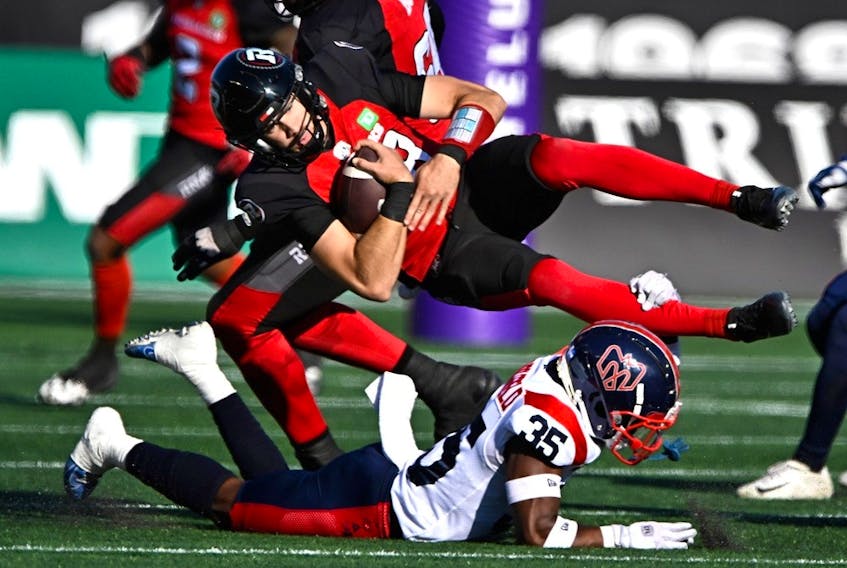 Redblacks quarterback Dustin Crum is tackled by the Alouettes'  Reggie Stubblefield ni the first half.