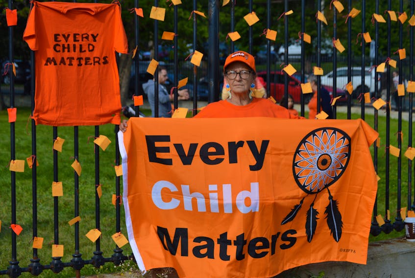 Saturday, September 30, 2023, was National Truth & Reconciliation Day, and also Orange Shirt Day. And the First Light Native Friendship Centre celebrated the occasion at the Colonial Building. Above, Sylvia Murphy, with the group NL Change Makers, displays an Every Child Matters flag as she stands alongside the iron fence outside the Colonial Building on Military Road at the rally.
-Photo by Joe Gibbons/SaltWire