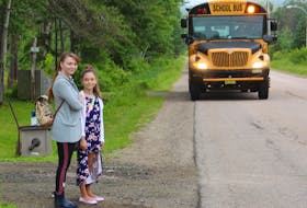 In this file photos from June, Paula Barnaby (front) stands with her daughter Rebecca Palickova, 8, as the bus arrives for pickup on the last day of school along Coxheath Road in Blacketts Lake. From Slovakia, the family moved to Cape Breton in early 2023 and Barnaby praised the teachers at her daughter's school. NICOLE SULLIVAN/CAPE BRETON POST