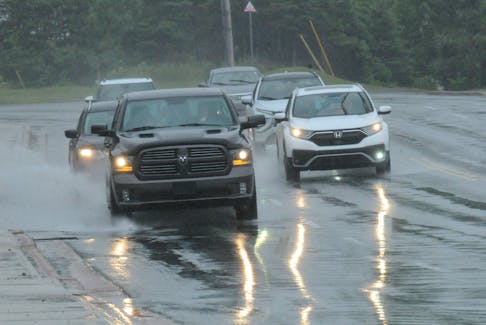 SHOT 06 AUGUST 2023 JOE GIBBONS/The Telegram	 The headlights of vehicles are reflected in the water on the roadway on Topsail Road in Paradise on Sunday morning, August 6, 2023, as they head northbound inwards to the town as the rain showers were falling amidst the water build-up on the blacktop. —Photo by Joe Gibbons/SaltWire  -Saltwire photo by Joe Gibbons/The Telegram