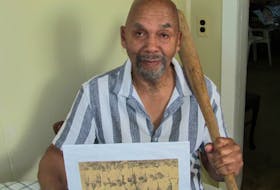 Cyril Maxwell holding a baseball bat and a photo of photograph of his old team, the 1959 Maritime champion Truro Kiwanis Juveniles. Contributed