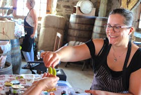 Dominique Chartrand hands out chocolate samples to guests at the Fortress of Louisbourg on Sept. 9. Chartrand owns Chocolat Voyageur - a chocolate shop in Miramichi, N.B., that makes products such as chocolate bars from scratch. While explaining her store's chocolate-making process, Chartrand said her methods aren't all that different from how it was done in Louisbourg more than 250 years ago.