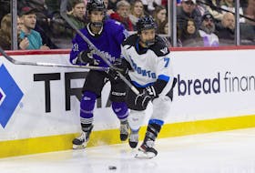 Minnesota forward Sophia Kunin (11) works against Toronto defender Olivia Knowles (7) for the puck during the first period of a PWHL hockey game Wednesday, Jan. 10, 2024, in St. Paul, Minn.
