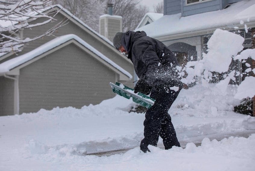Zach Brobst shovels in his driveway after a snowstorm left several inches of snow in Clive, Iowa, U.S., January 9, 2024.