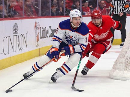 Zach Hyman #18 of the Edmonton Oilers controls the puck in front of Jake Walman #96 of the Detroit Red Wings during the first period at Little Caesars Arena on January 11, 2024 in Detroit, Michigan.