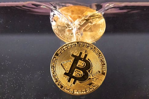Souvenir tokens representing cryptocurrency Bitcoin plunge into water in this illustration taken May 17, 2022.