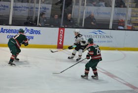 Charlottetown Islanders forward Ross Campbell, 15, of Souris dumps the puck into the Halifax Mooseheads’ end during a Quebec Maritimes Junior Hockey League game at Eastlink Centre on Jan. 7. Halifax defencemen Jake Furlong, left, and Owen Phillips, 26, pressure Campbell on the play. The Islanders are back in action at Eastlink Centre on Jan. 14 against the Quebec Remparts at 3 p.m. Jason Simmonds • The Guardian