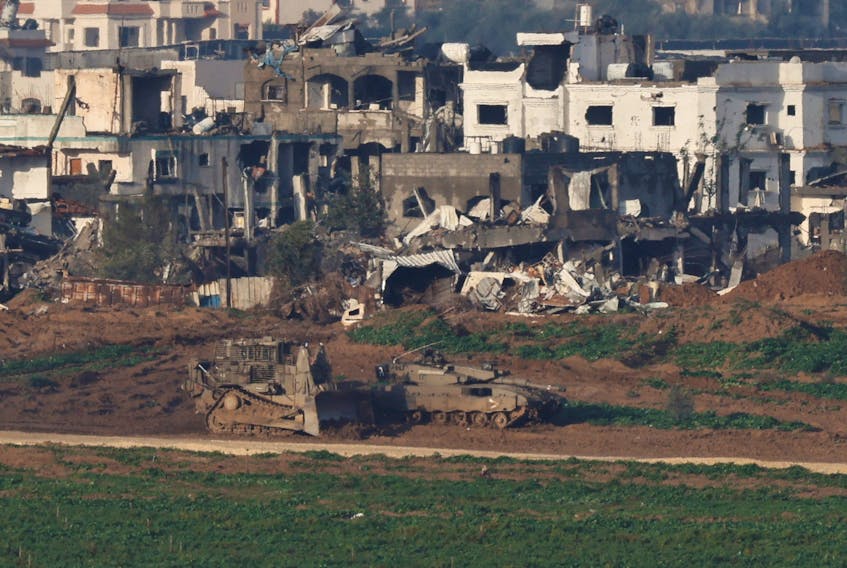 Israeli military vehicles manoeuvre in Gaza, amid the ongoing conflict between Israel and the Palestinian Islamist group Hamas, as seen from Israel, January 12, 2024.