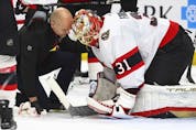Senators goaltender Anton Forsberg (31) talks with a trainer after being injured in the first period of Thursday's game at Buffalo.
