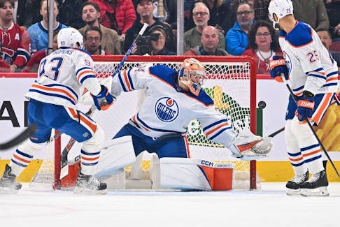 Edmonton Oilers goaltender Stuart Skinner (74) reaches for the puck against the Montreal Canadiens at Bell Centre on Saturday, Jan. 13, 2024, in Montreal.